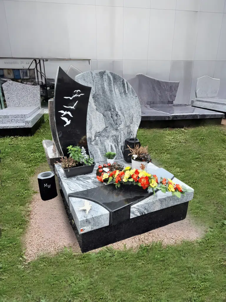 Monument cinéraire contemporain en granit avec stèle gravée d'oiseaux.